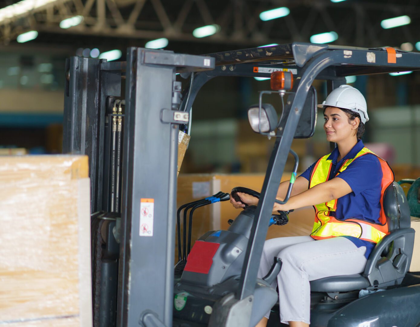 Warehouse worker driving a forklift safely.
